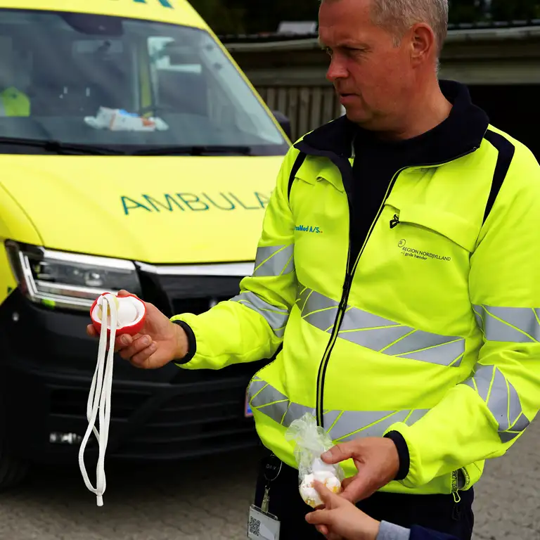Ambulanceredder Jesper Løgsted viser - ved hjælp af to hønseæg - børnene, hvad der sker med deres hoved, hvis de ikke har cykelhjelm på og de rammer hovedet i asfalten.